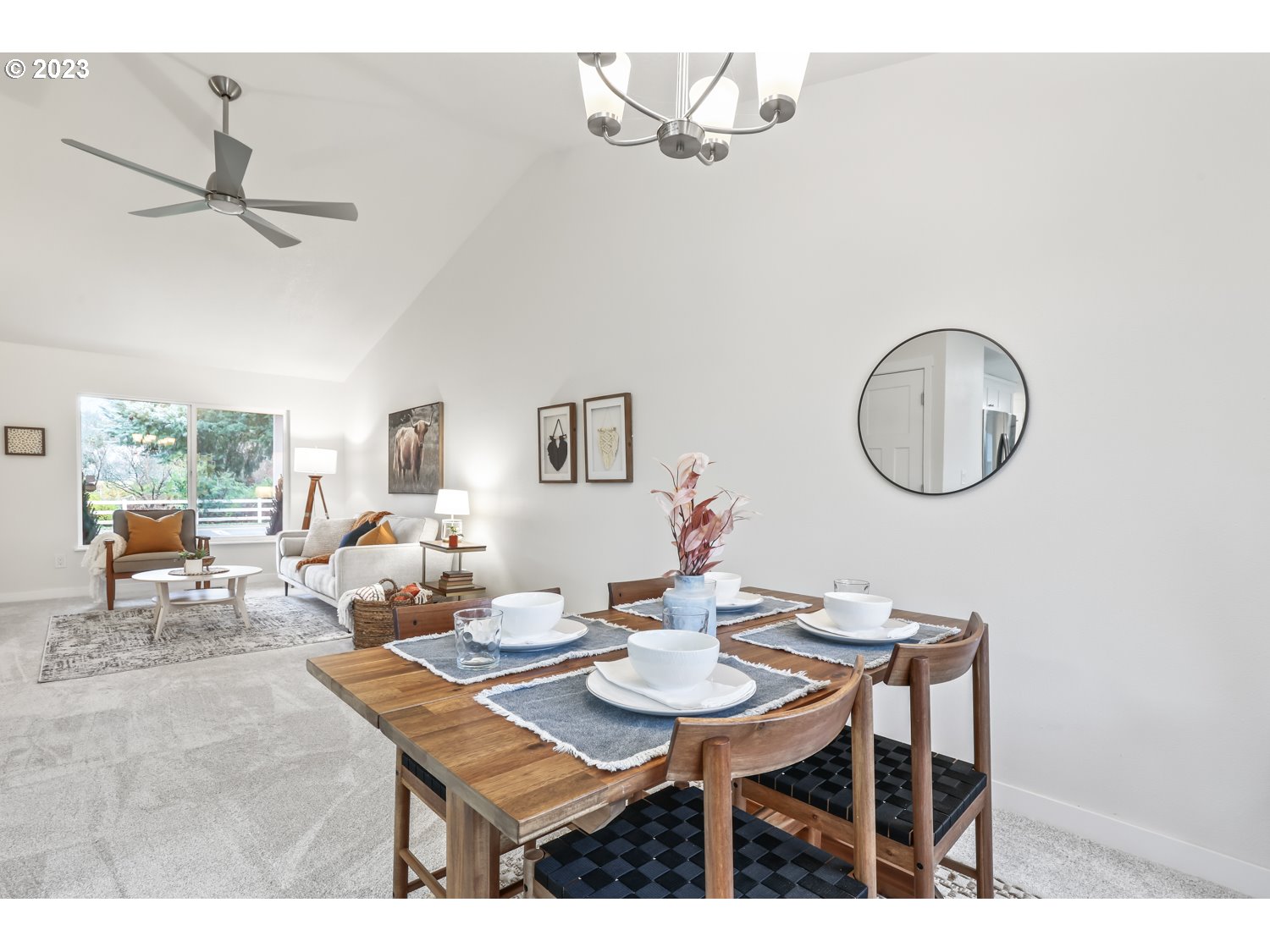 1203 Southeast Barnes Road Gresham, OR 97080 - Photo 9 of 43 a dining room with wooden floor a chandelier fan a wooden table and chairs