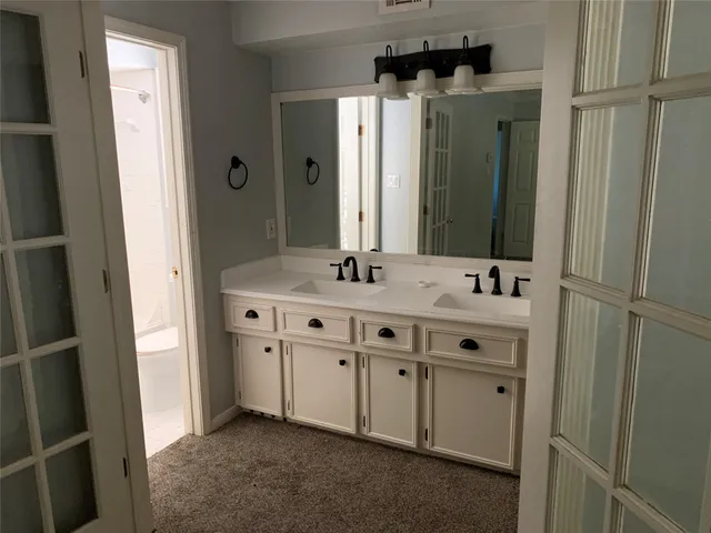 a bathroom with a double vanity sink and mirror