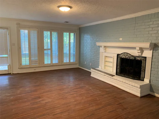 a view of an empty room with exposed radiator and fireplace