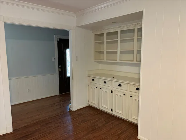 an empty room with wooden floor and cabinet