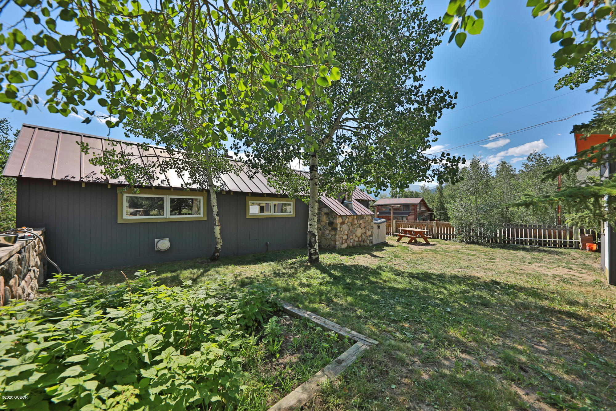 539 Kings Crossing Road Winter Park, CO 80482 - Photo 28 of 35 a backyard of a house with plants and a tree