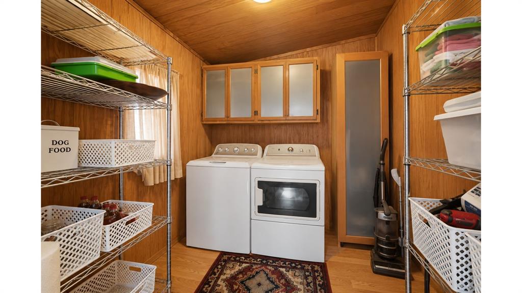 117 Reading Avenue North Center Point, TX 78010 - Photo 18 of 20 Dedicated laundry area featuring a washer and dryer, wood-finish flooring, and wood-paneled walls