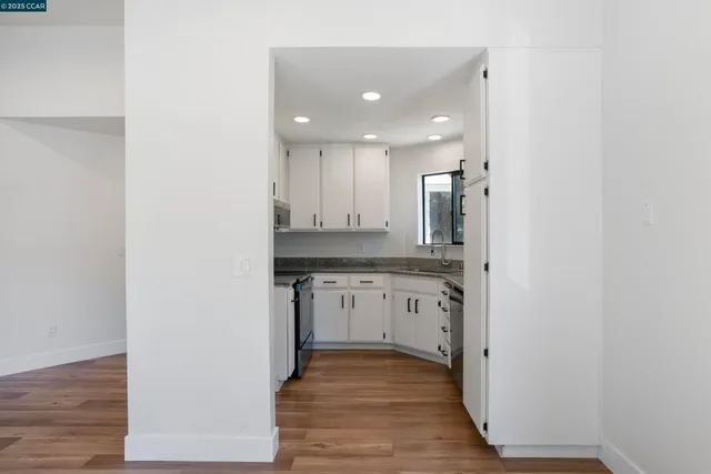 an empty room with wooden floor and a sink