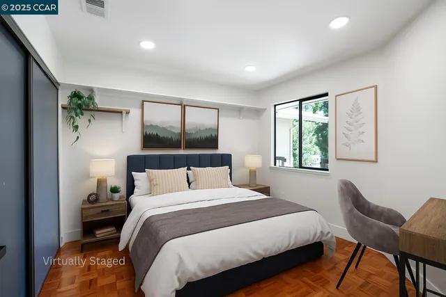 a bedroom with a bed window and mirror