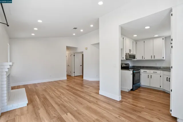 a view of kitchen with granite countertop stainless steel appliances refrigerator sink and cabinets