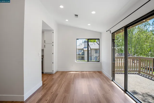 a view of hallway with a large window and wooden floor