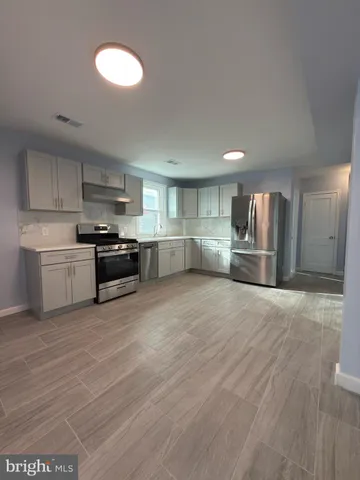 a large kitchen with cabinets and stainless steel appliances