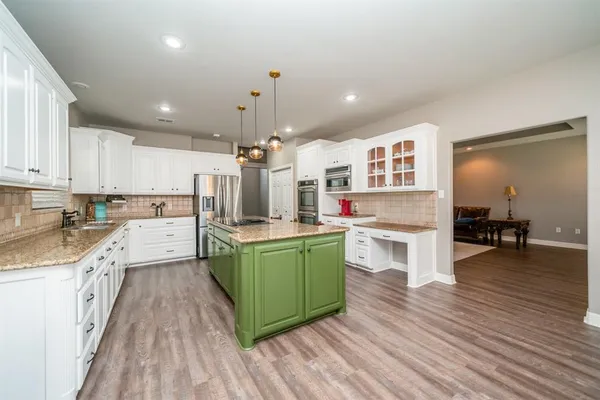 a kitchen with lots of counter top space and wooden floor