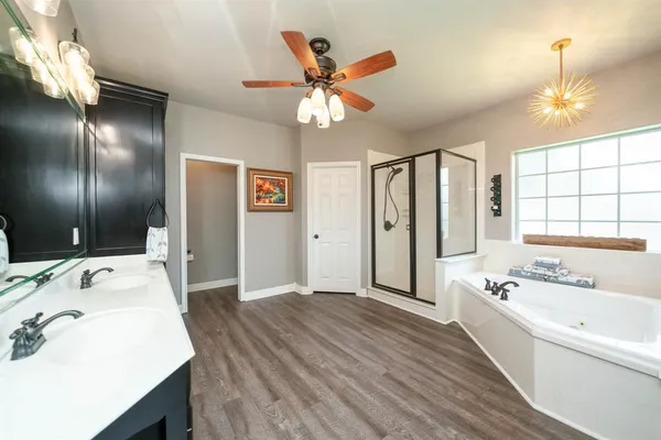 a spacious bathroom with a double vanity sink a large mirror and shower