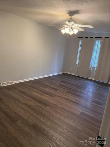 a view of a livingroom with wooden floor and a large window