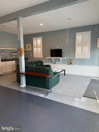 a living room with a table chairs and a refrigerator