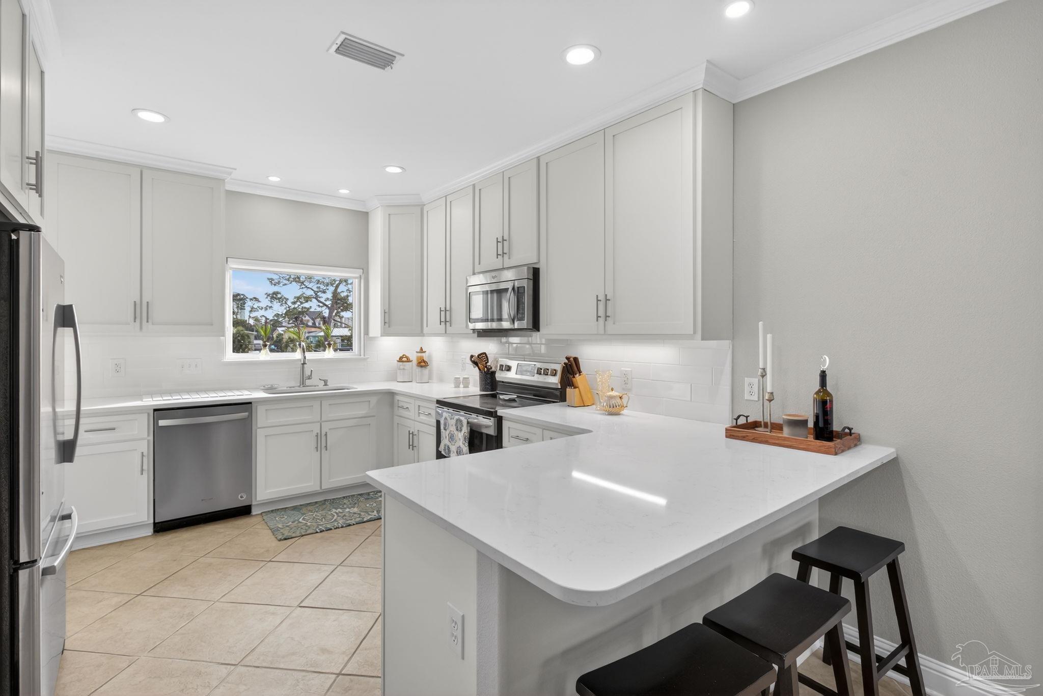 26355 Marina Road Orange Beach, AL 36561 - Photo 16 of 58 a kitchen with white cabinets and white appliances