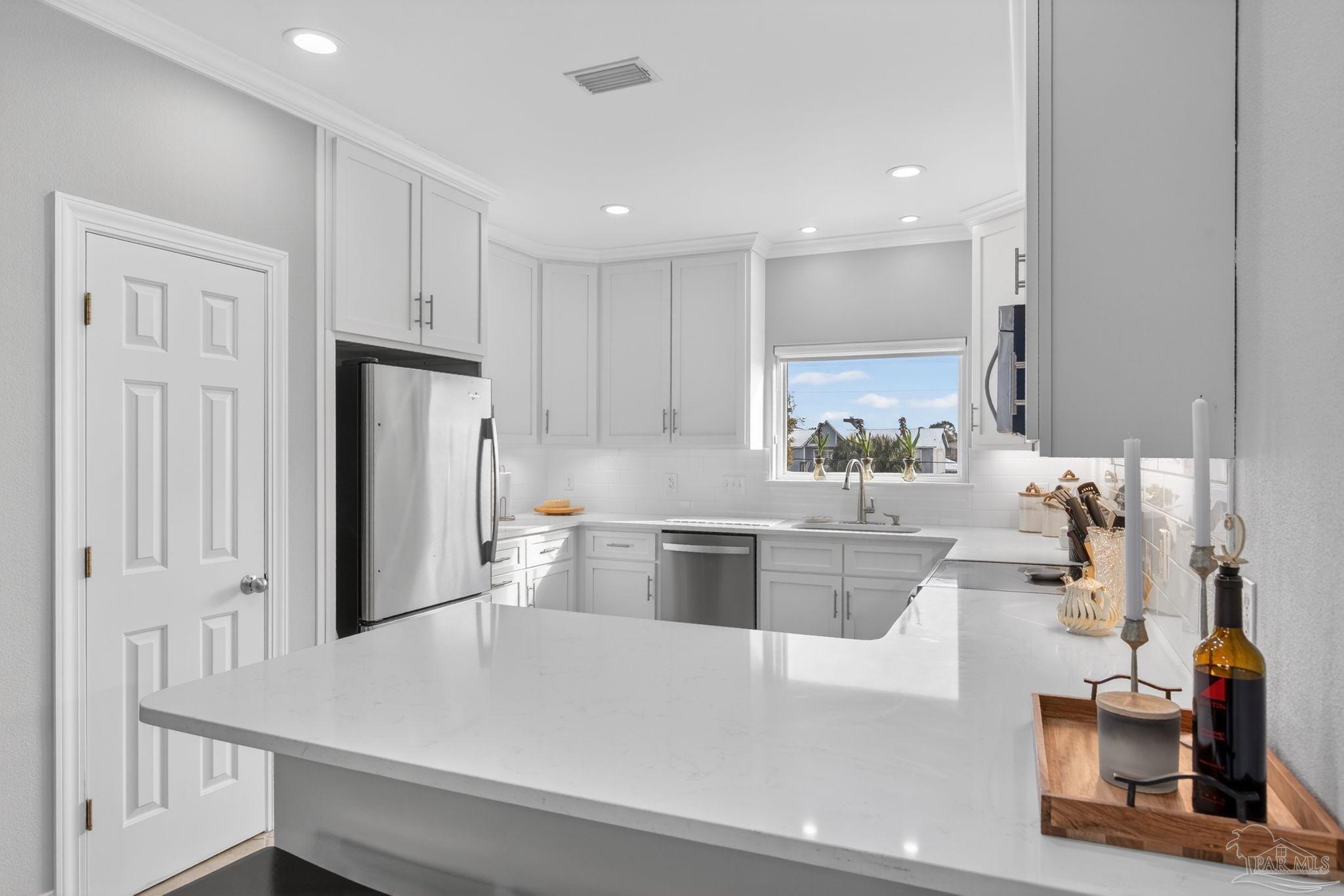 26355 Marina Road Orange Beach, AL 36561 - Photo 17 of 58 a large white kitchen with a refrigerator a stove a sink and a cabinets