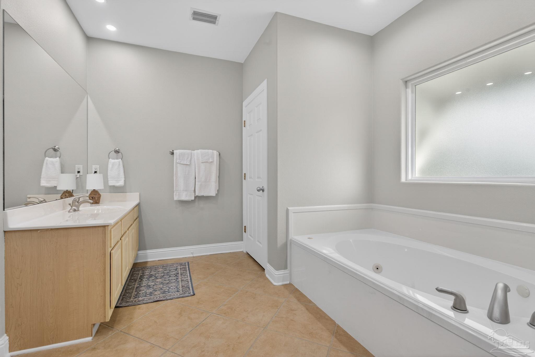 26355 Marina Road Orange Beach, AL 36561 - Photo 21 of 58 a bathroom with a tub sink and mirror