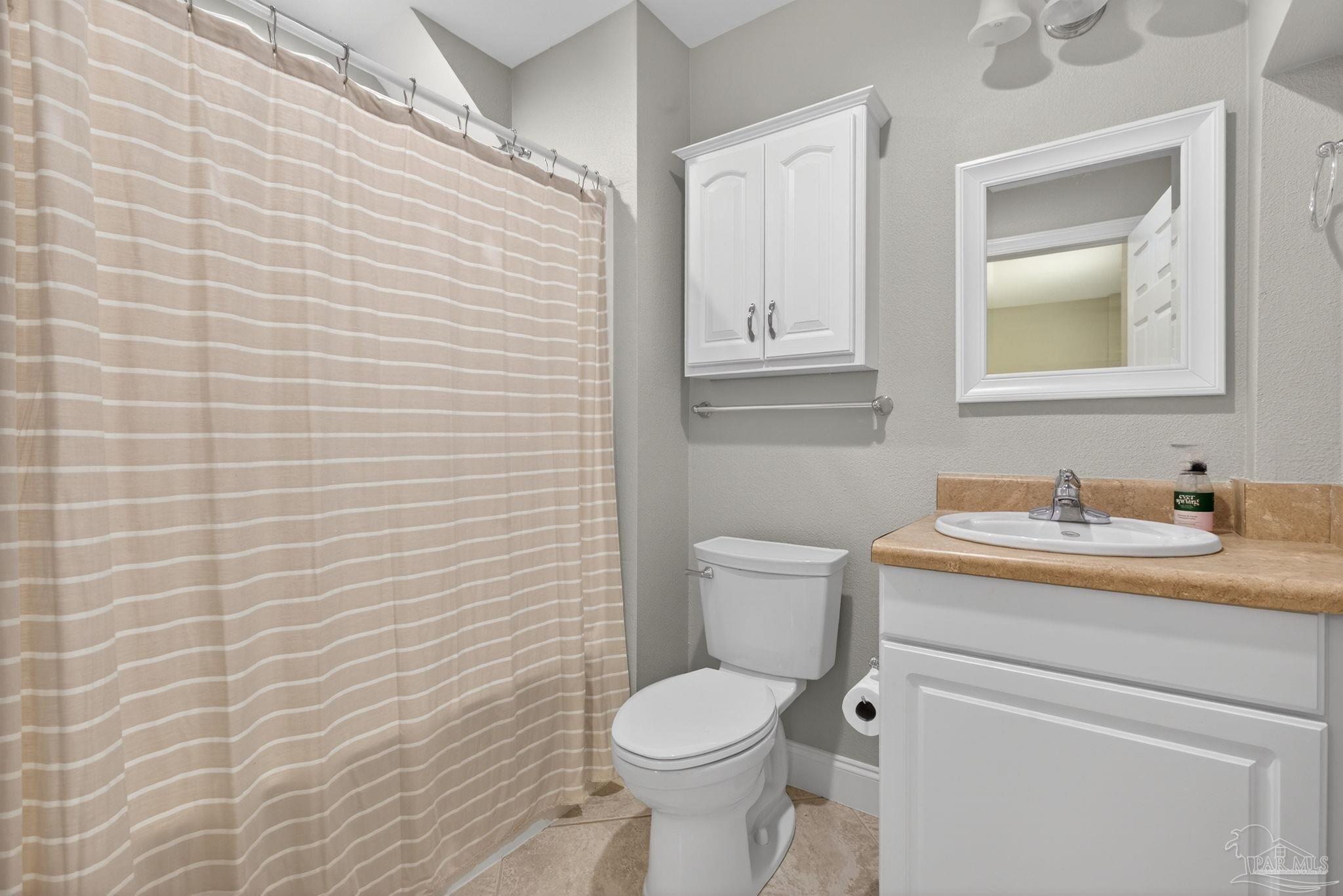 26355 Marina Road Orange Beach, AL 36561 - Photo 35 of 58 a bathroom with a granite countertop toilet a sink and mirror