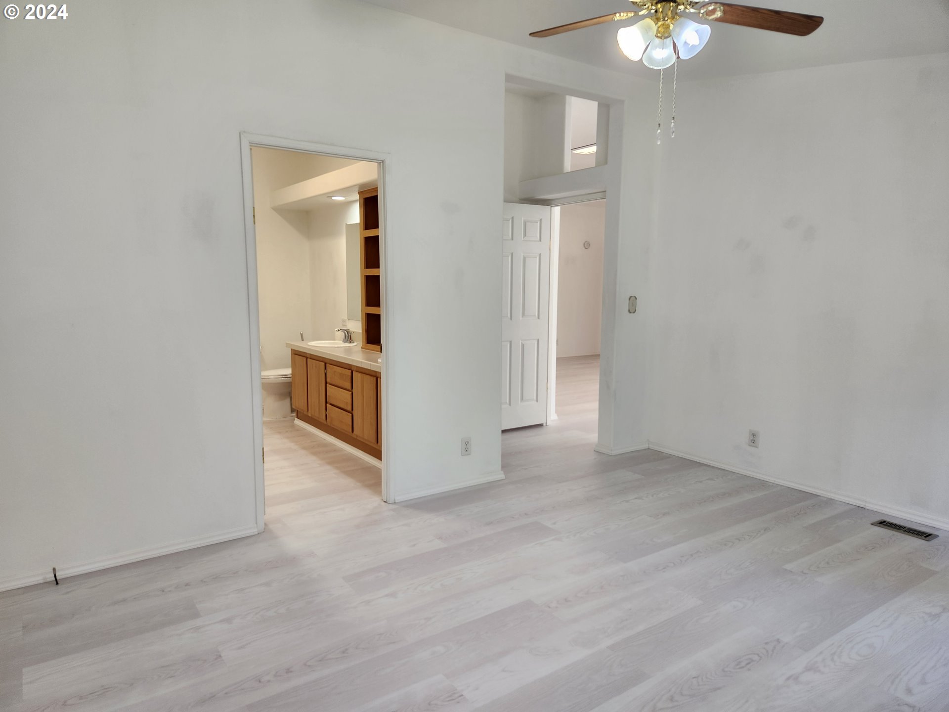 1675 Kristi Loop Lakeside, OR 97449 - Photo 15 of 30 an empty room with wooden floor chandelier fan and windows
