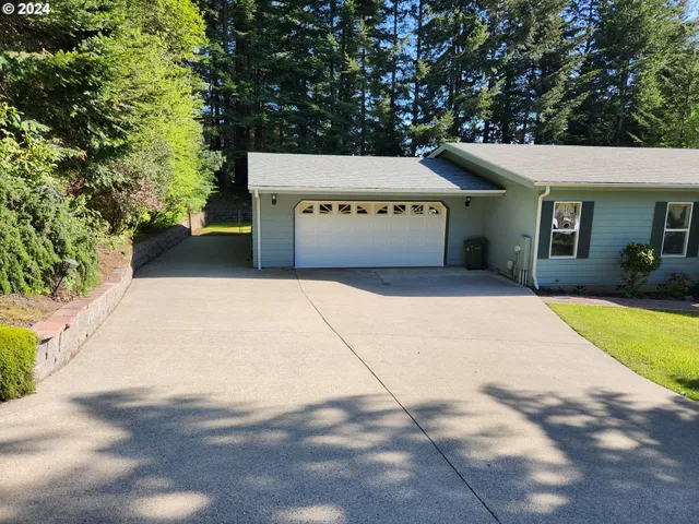 a view of a house with a yard and large tree