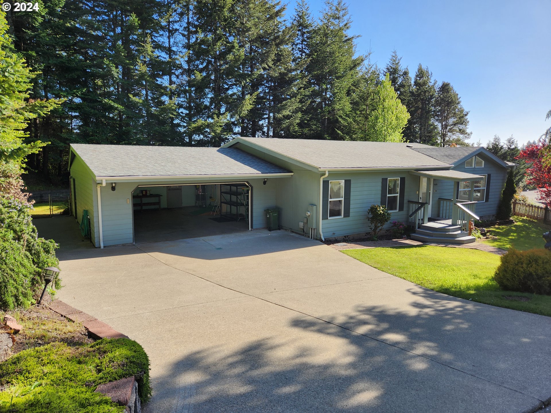 1675 Kristi Loop Lakeside, OR 97449 - Photo 29 of 30 a front view of a house with a yard and garage