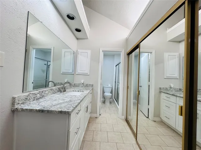 a bathroom with a granite countertop sink and a mirror