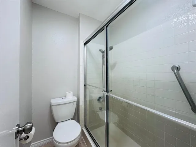 a white toilet sitting next to a shower