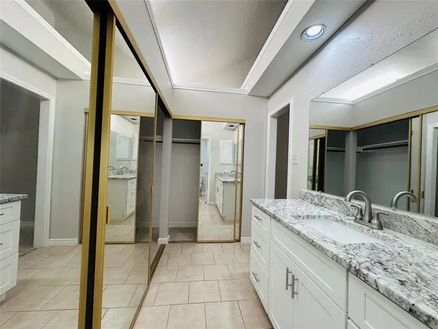 a bathroom with a granite countertop sink and a mirror