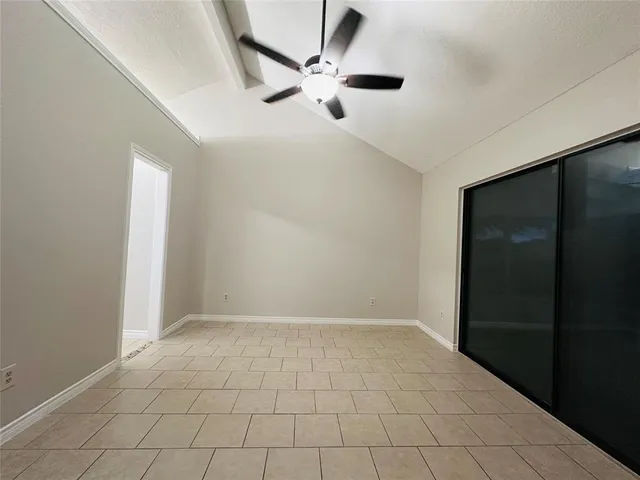 en empty room with ceiling fan and window
