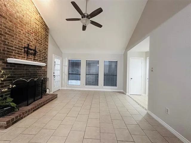 a view of an empty room with a fireplace and a window