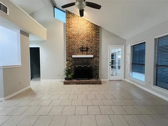 a view of an empty room with a fireplace and a window