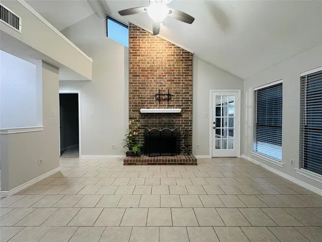 a view of an empty room with a fireplace and a window