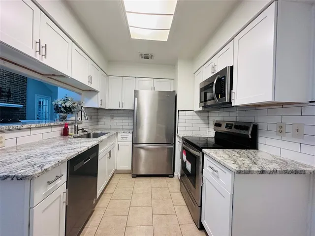 a kitchen with a sink a microwave and refrigerator