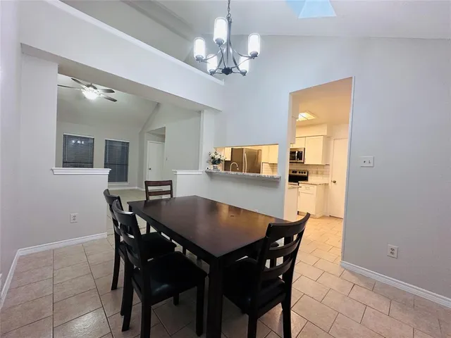 a view of a dining room with furniture and chandelier