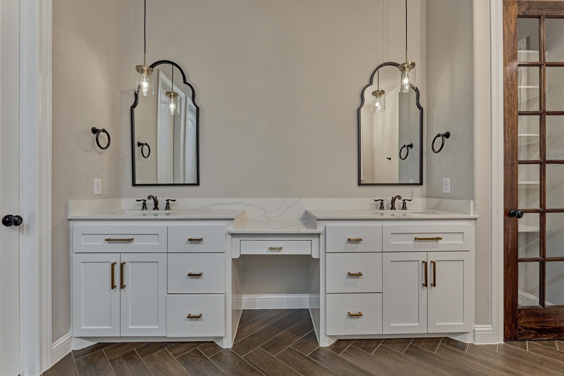 11618 Renaissance Drive Montgomery, TX 77356 - Photo 19 of 49 The sink area is highlighted by the arched top mirrors, gold hardware and pendant lighting. A stained wood glass-paned door to the right offers a designer-inspired look for your linen closet.