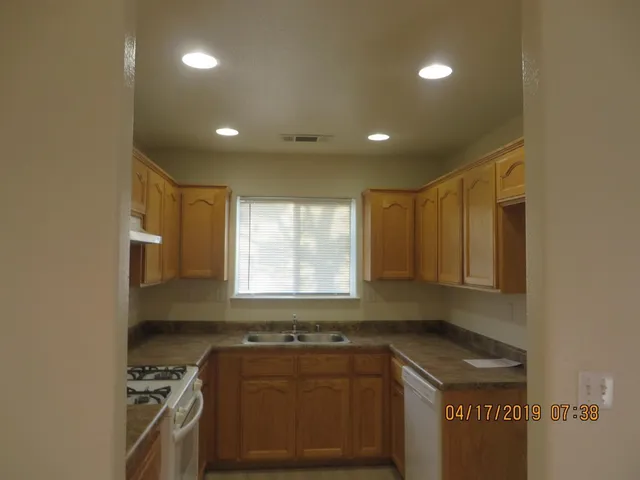 a kitchen that has a sink a stove and cabinets