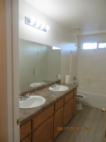 a bathroom with a granite countertop sink a toilet and a mirror