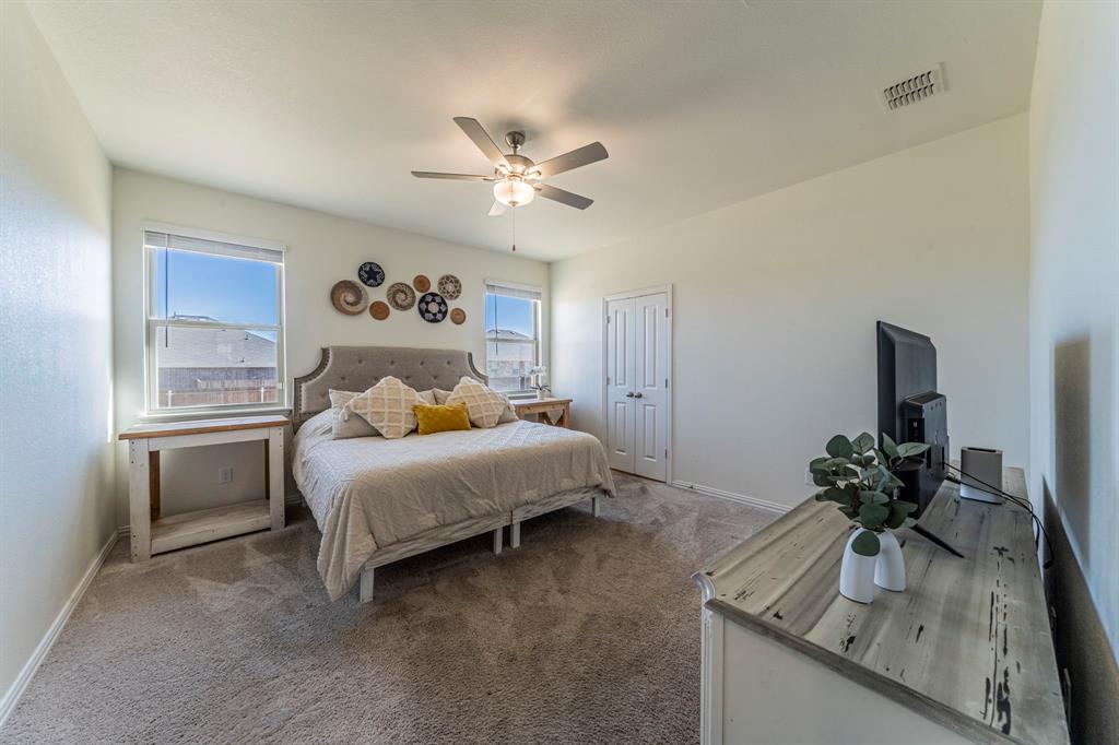1240 Almond Road Azle, TX 76020 - Photo 9 of 26 a bedroom with a bed and a chandelier