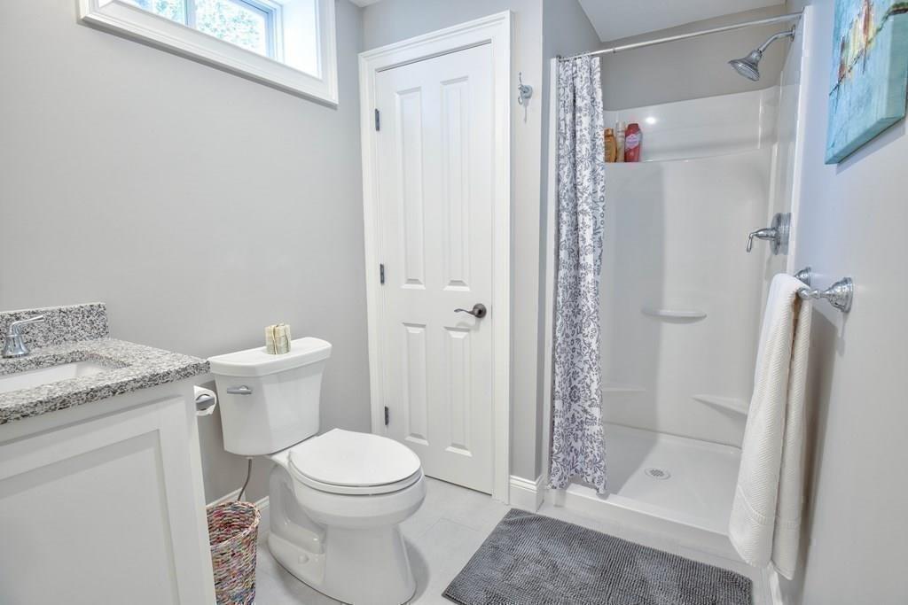 185 Cross Street Winchester, MA 01890 - Photo 32 of 41 a bathroom with a granite countertop toilet a sink and shower