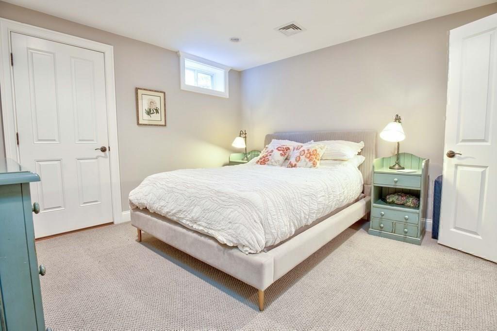 185 Cross Street Winchester, MA 01890 - Photo 36 of 41 a bedroom with a bed and a lamp