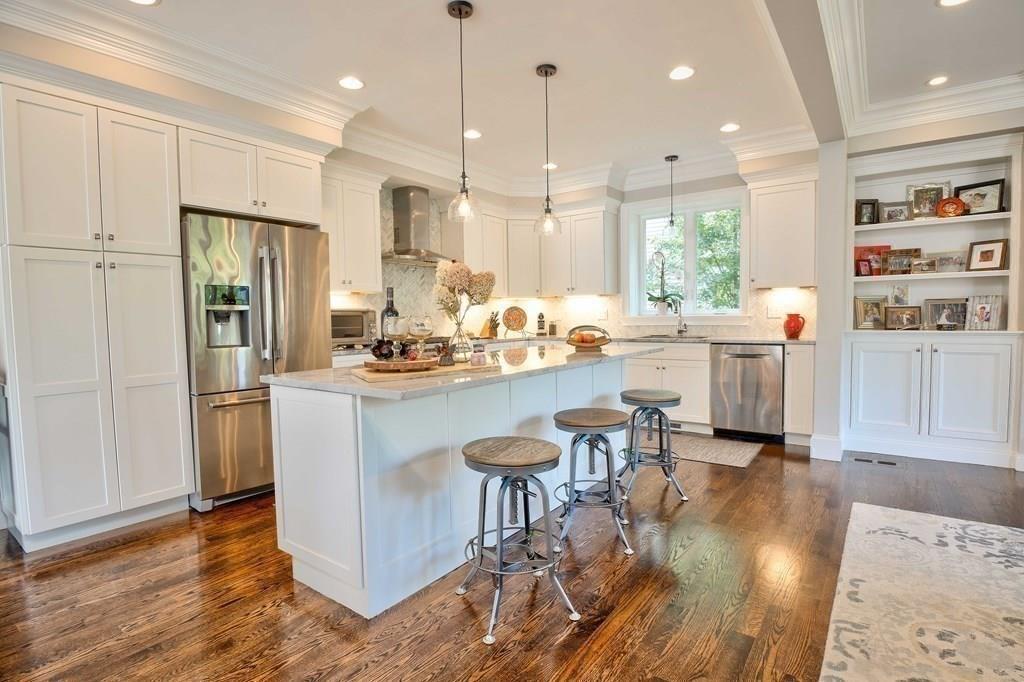 185 Cross Street Winchester, MA 01890 - Photo 9 of 41 a room with stainless steel appliances kitchen island granite countertop a refrigerator a stove a sink and a dining table with wooden floor