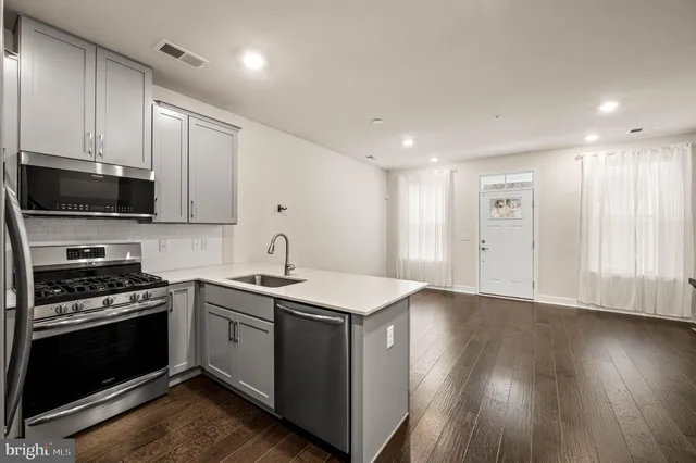 a kitchen with stainless steel appliances granite countertop a stove a sink and a microwave