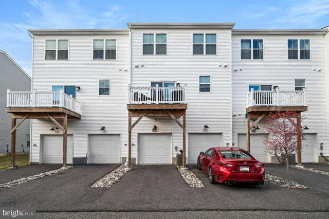 a front view of a house with a parking space