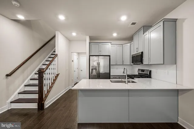 a view of kitchen with sink microwave and refrigerator