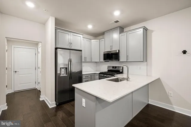 a kitchen with a refrigerator a microwave and sink