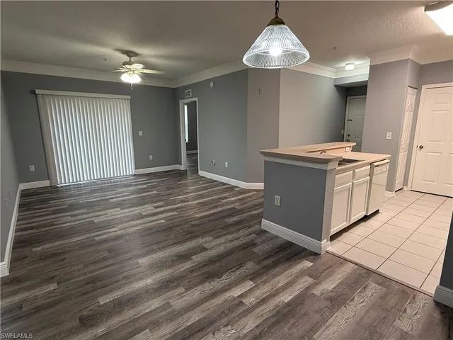 a kitchen with kitchen island granite countertop a stove and a wooden floors