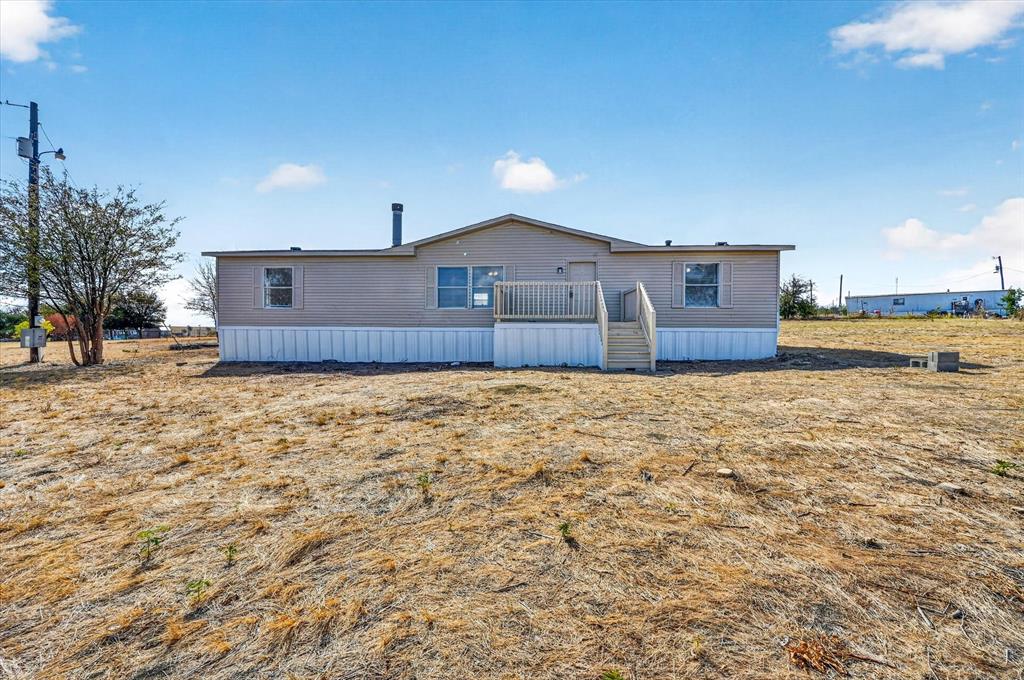 246 PR-4443 Rhome, TX 76078 - Photo 1 of 35 Single-story residence featuring light-toned siding, a front porch with railing, and a sloped roof