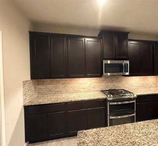 a kitchen with granite countertop stainless steel appliances and cabinets