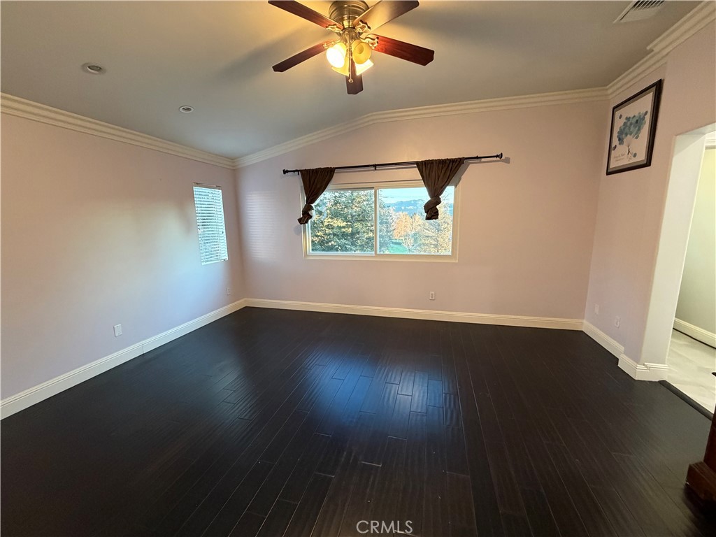 32044 Cypress Way Castaic, CA 91384 - Photo 32 of 59 an empty room with wooden floor chandelier fan and windows