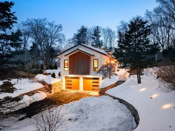 a front view of a house with a yard covered with snow