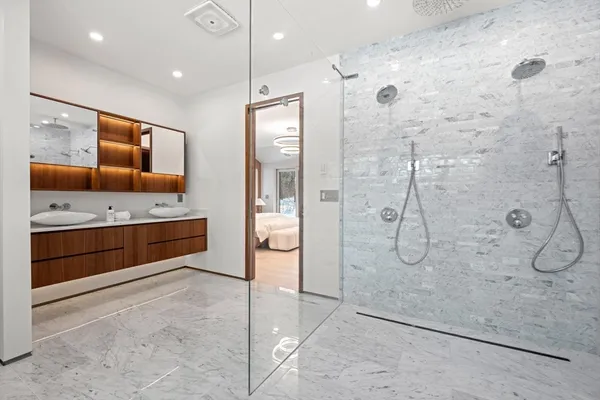 a bathroom with a double vanity sink a large mirror and shower