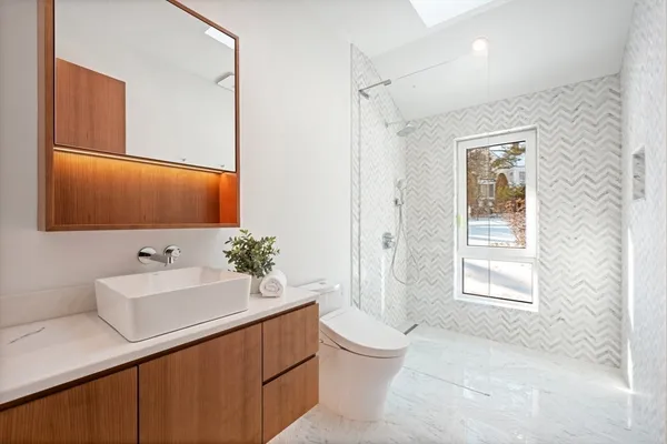 a bathroom with a sink toilet and mirror
