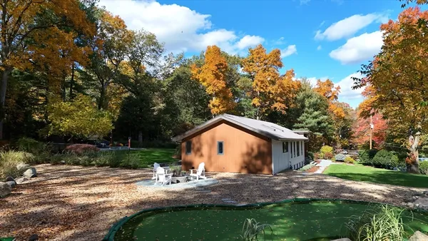 a view of a house with backyard and trees
